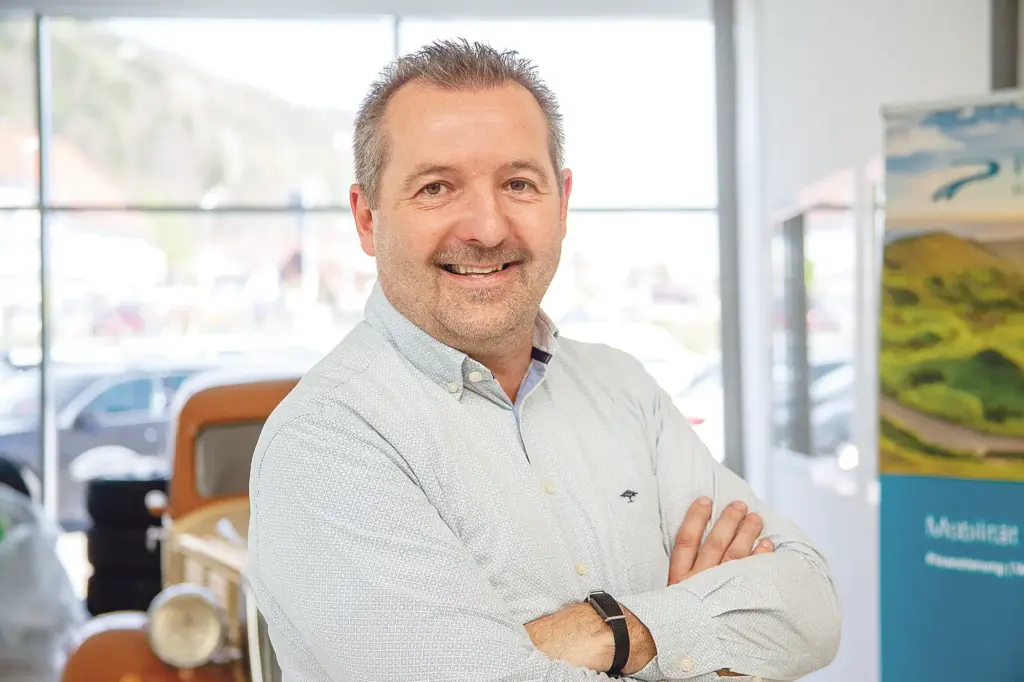 Ein Mann mit Dreitagebart und verschränkten Armen