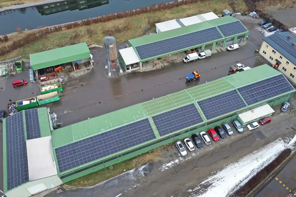 Luftaufnahme eines Betriebsgeländes mit Photovoltaik-Paneelen auf den Dächern der Gebäude