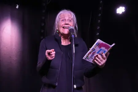 Eine Frau mit einem Buch vor einem Mikrofon