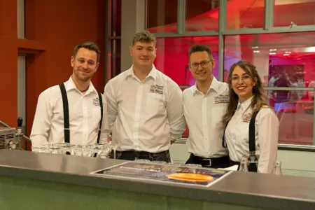 Vier Personen hinter einer Bar