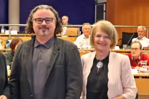 Ein Mann und eine Frau stehen in einem Sitzungssaal