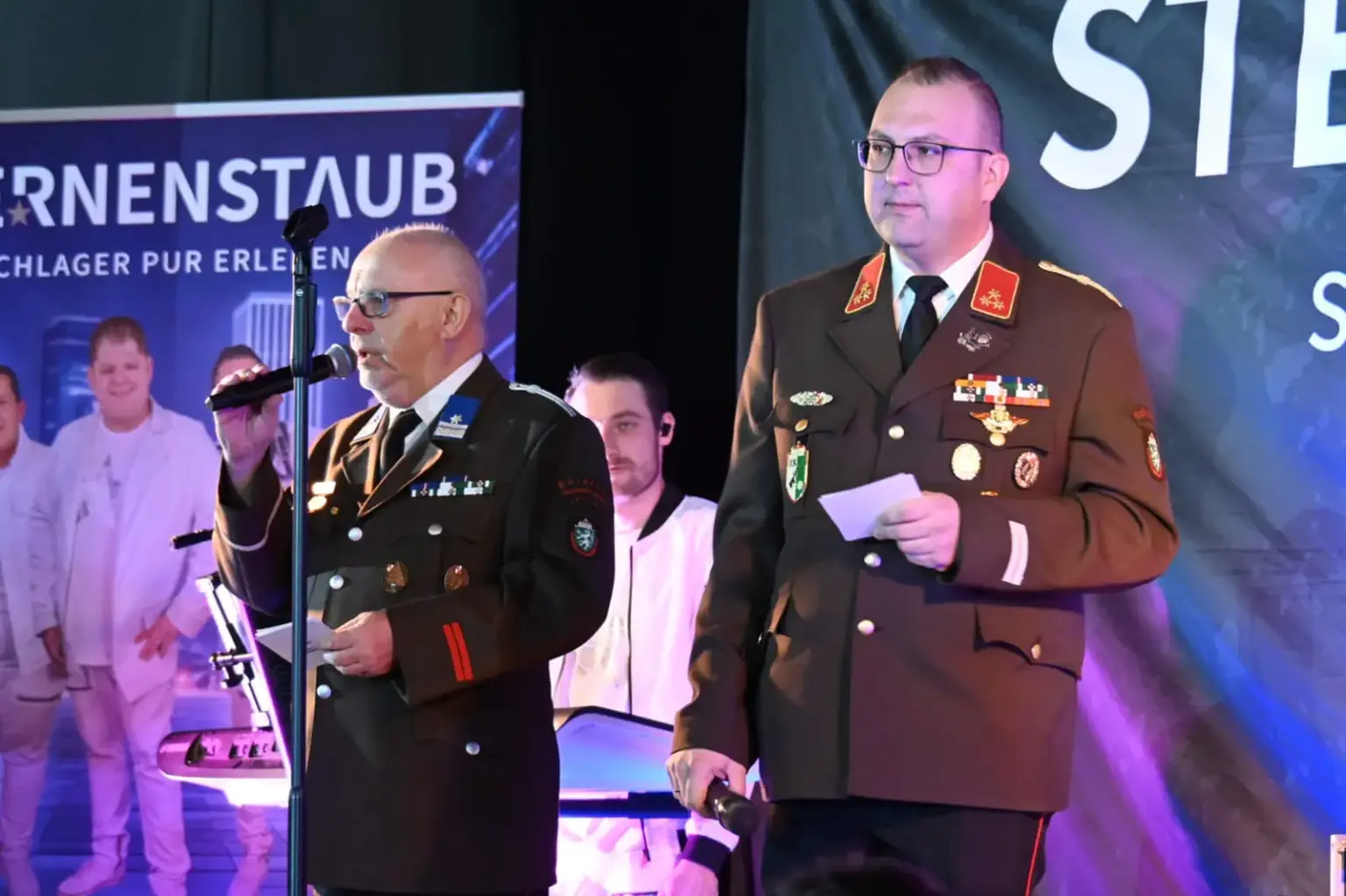 Zwei Männer in Feuerwehr-Uniform auf einer Bühne