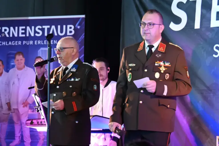 Heißes Tanzparkett in kalter Nacht Zwei Männer in Feuerwehr-Uniform auf einer Bühne