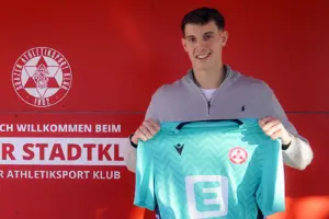 Junger Mann mit einem Fußballtrikot in der Hand