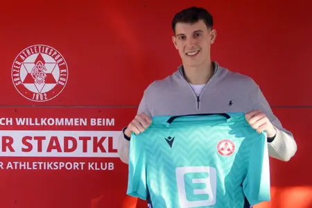 Junger Mann mit einem Fußballtrikot in der Hand