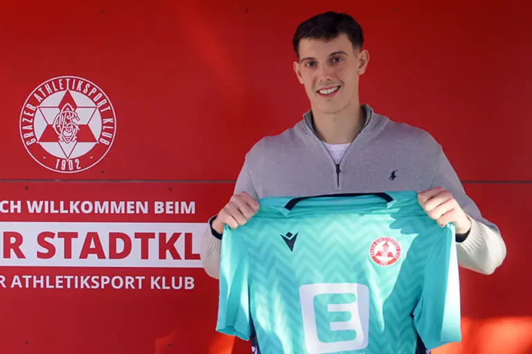 Junger Mann mit einem Fußballtrikot in der Hand