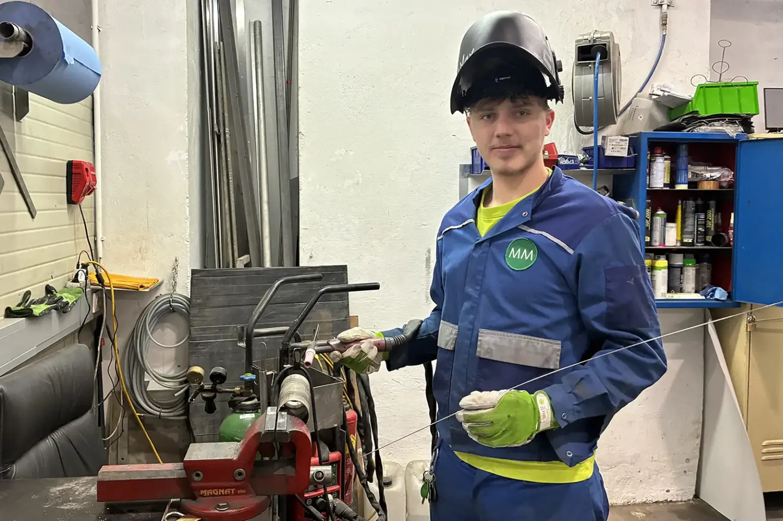 „Kann handwerklich tätig sein“ Ein junger Mann mit Helm in einer Werkstatt.