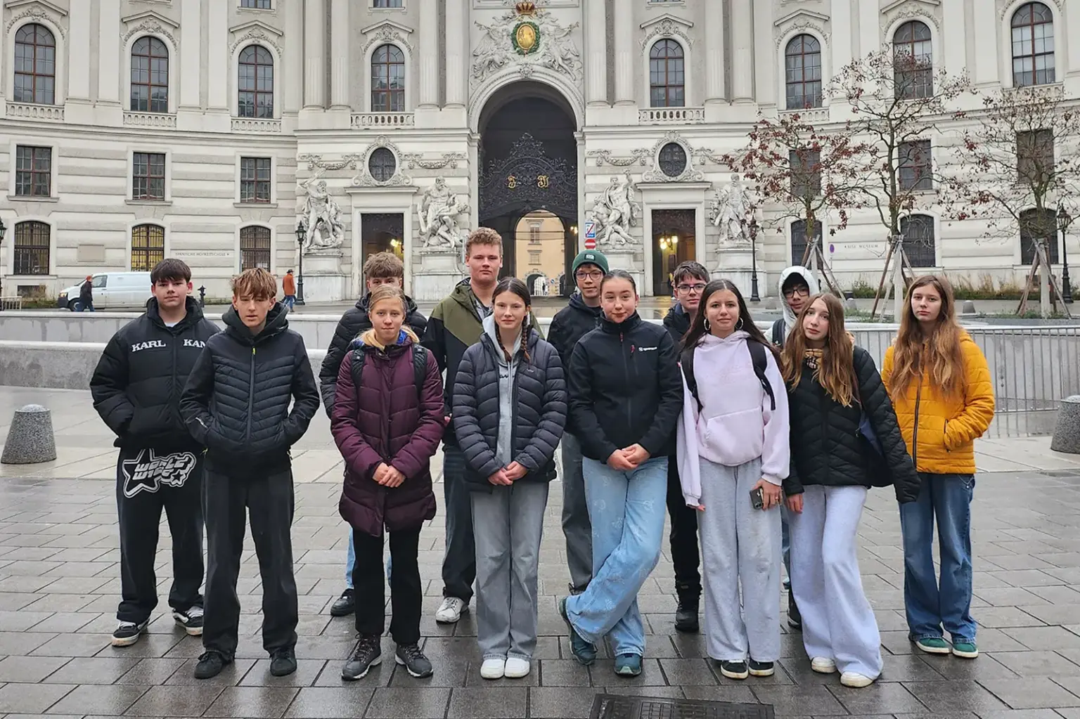 Eine Gruppe junger Menschen auf einem Platz vor einem historischen Gebäude