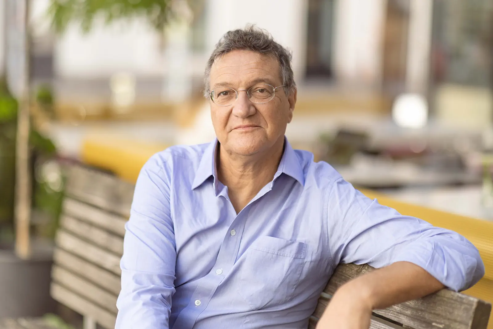 Ein Mann mit Brille auf einer Parkbank