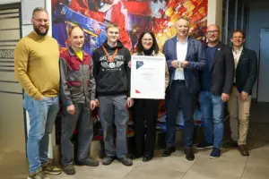 Talent für Förderung – und umgekehrt Sechs Personen vor einem Wandbild. Die Dame in der Mitte hält eine Auszeichnung in ihren Händen.