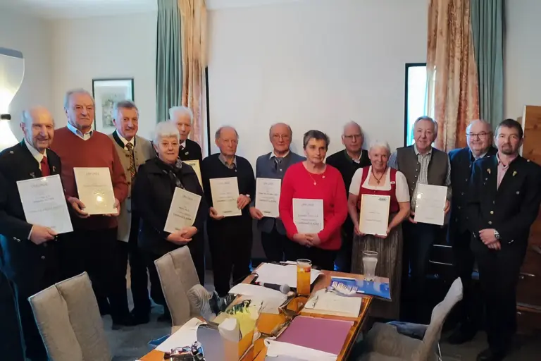 Ein Gruppe älterer Personen mit Urkunden