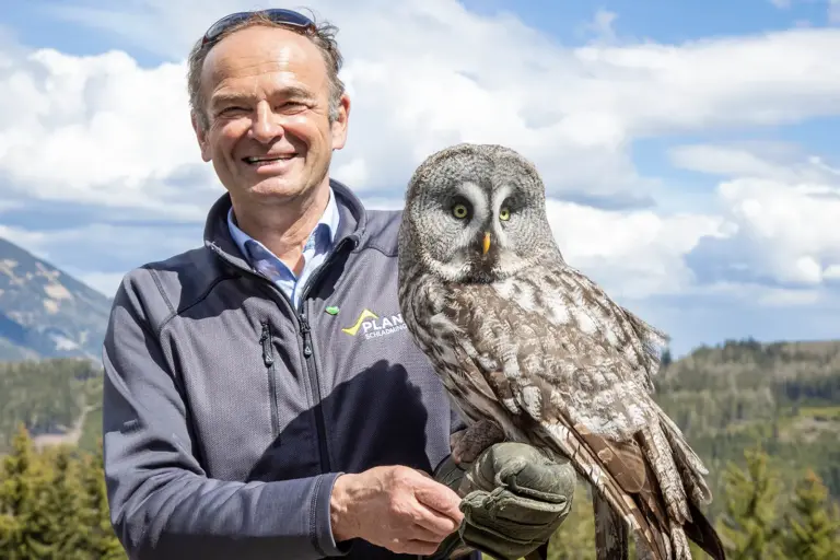 Ein Mann mit einem Bartkauz auf dem Arm