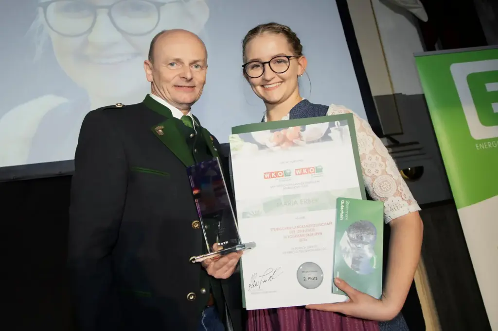 Ein Mädchen und ein Mann präsentieren einen Preis und eine Urkunde