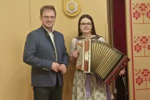 Vergoldetes Nachwuchstalent Ein Mann mit Brille und ein Mächen mit einer Harmonika