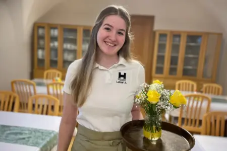 Eine junge Frau mit einem Tablett in der Hand.