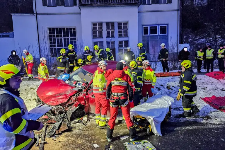 Ein Autowrack, ringsum Einsatzkräfte von Feuerwehr, Rotem Kreuz, Polizei und Flugrettung
