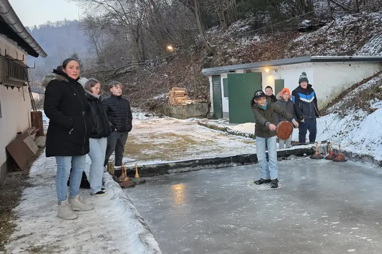 Eine Gruppe Jugendlicher beim Eisstockschießen