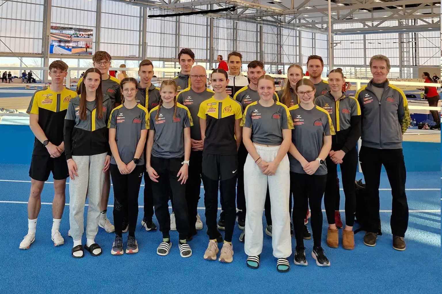 Eine Gruppe von Menschen in einer Leichtathletikhalle.