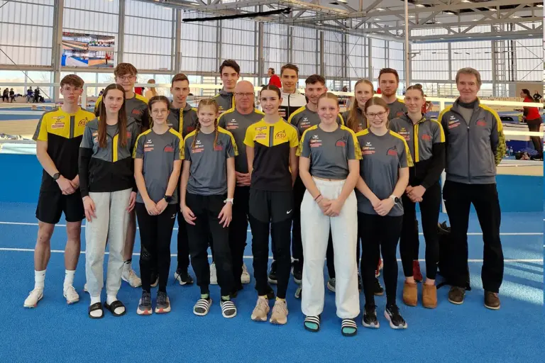 Eine Gruppe von Menschen in einer Leichtathletikhalle.