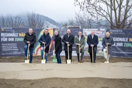 Sieben Männer vor einem Erdhaufen mit jeweils einem Spaten in der Hand.