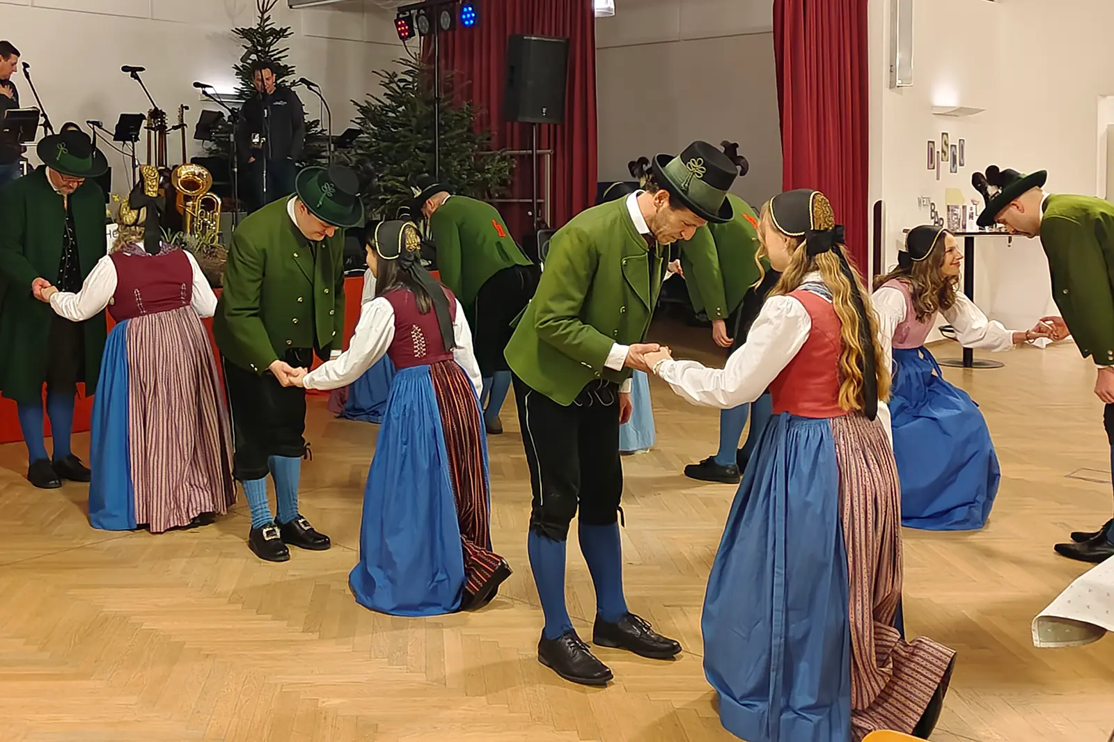 Männer und Frauen in Tracht tanzen
