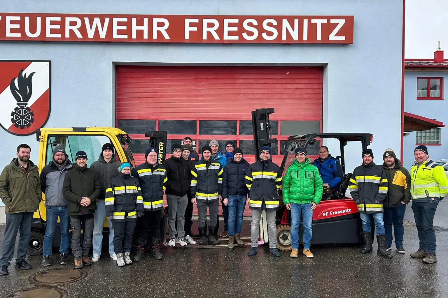 Ein Gruppe von Personen vor zwei Gabelstaplern