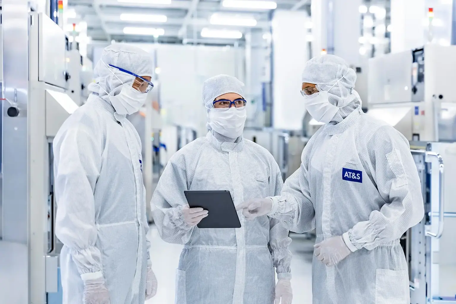 Drei Personen mit Schutzanzügen in einem Reinraum der AT&S Leoben.