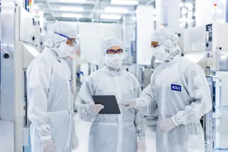 Drei Personen mit Schutzanzügen in einem Reinraum der AT&S Leoben.