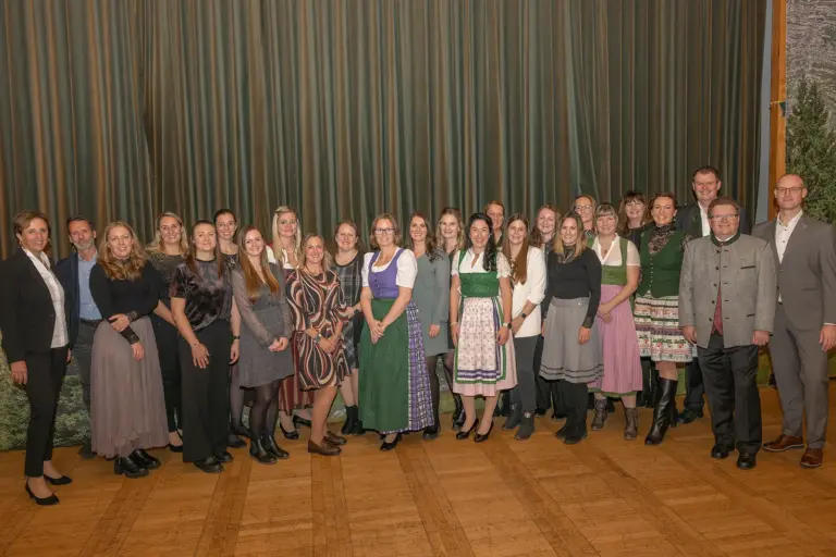 Eine Gruppe von rund 25 Personen in einem Festsaal