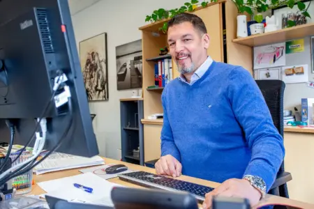 Ein Mann sitzt an einem Schreibtisch mit Computer