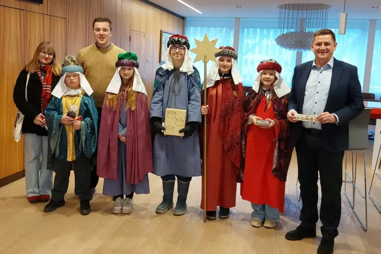 Sternsinger zu Gast im Rathaus Eine Gruppe von Sternsingern mit zwei Männern