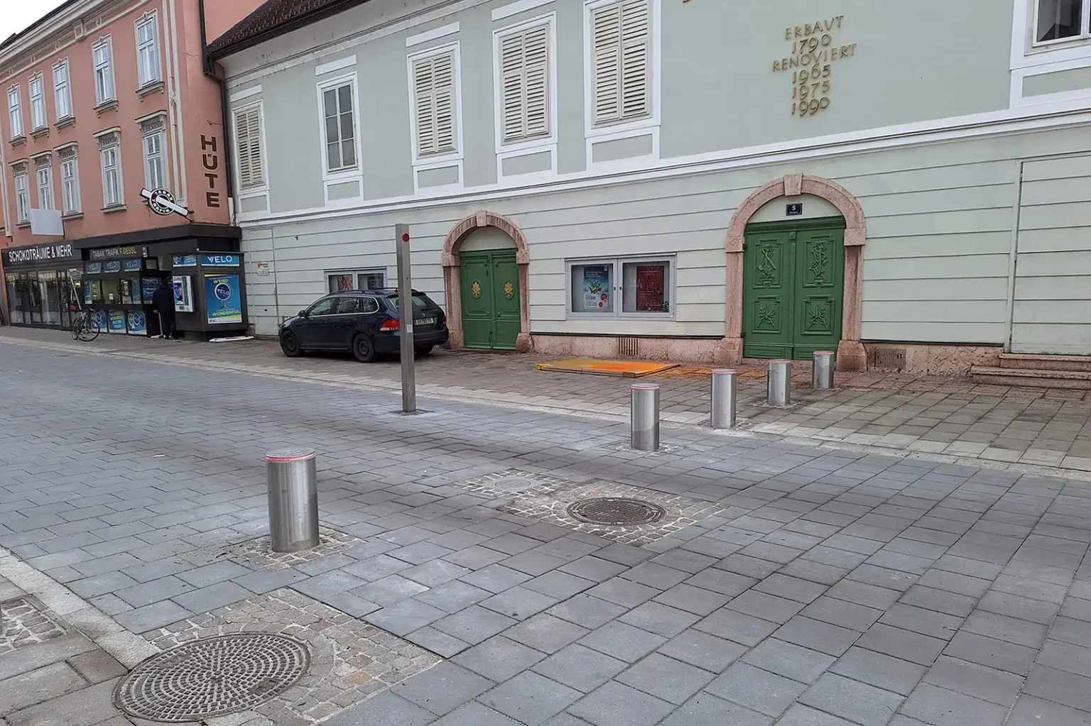 Versenkbare Straßensperren auf einer gepflasterten Fläche vor einer alten Fassade
