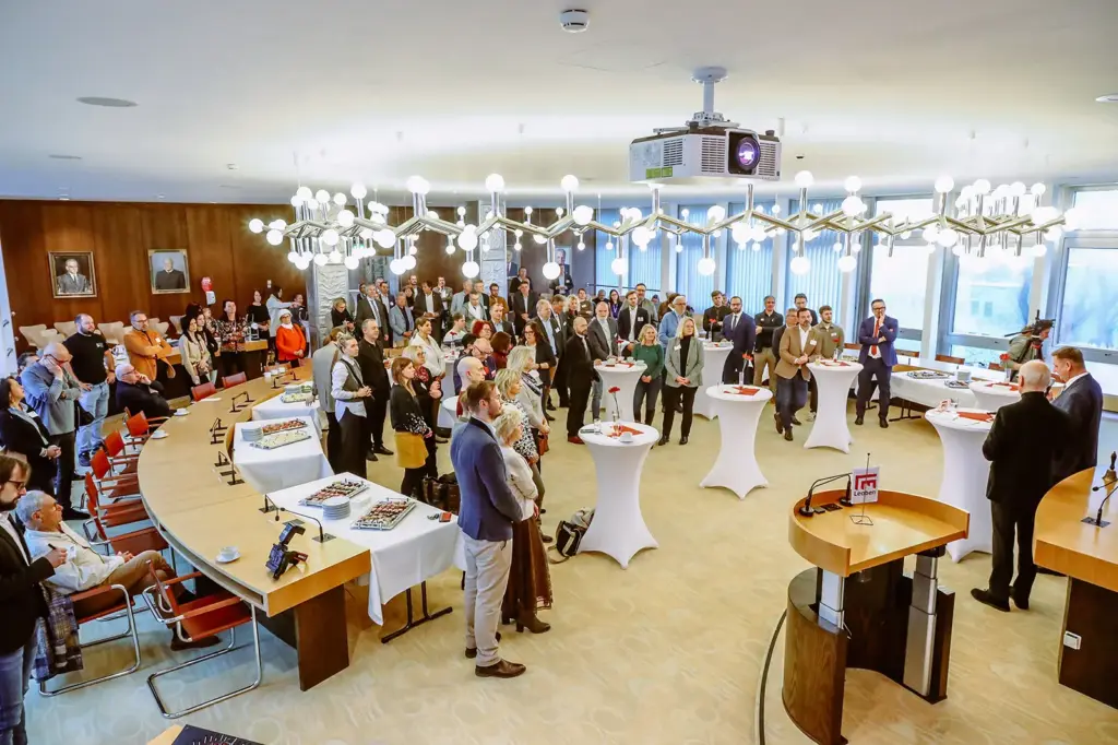 Viele Menschen hören zwei Sprechern zu.