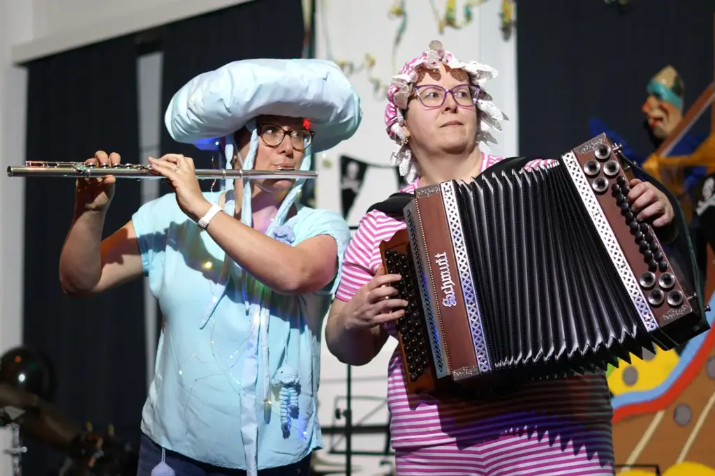 Zwei Personen in Kostümen spielen Querflöte und Harmonika