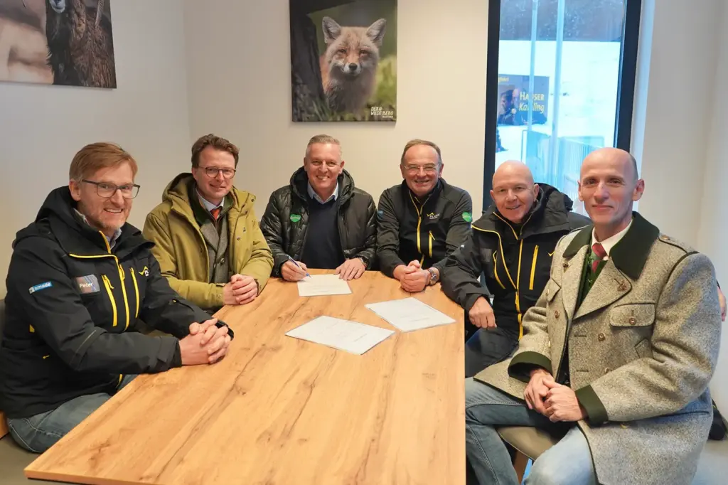 Sechs Männer sitzen an einem Tisch