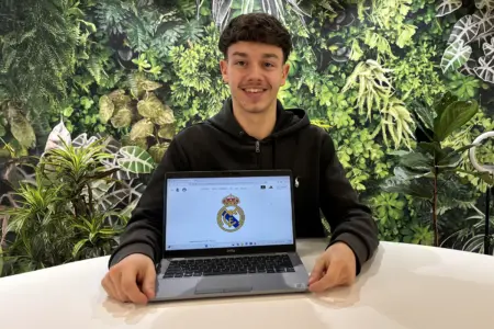 „Der Stundenplan ist super“ Ein junger Mann sitzt, vor ihm auf dem Tisch steht ein Laptop.