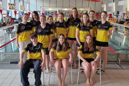 Eine Gruppe junger Menschen beim Gruppenfoto in einem Schwimmbad.