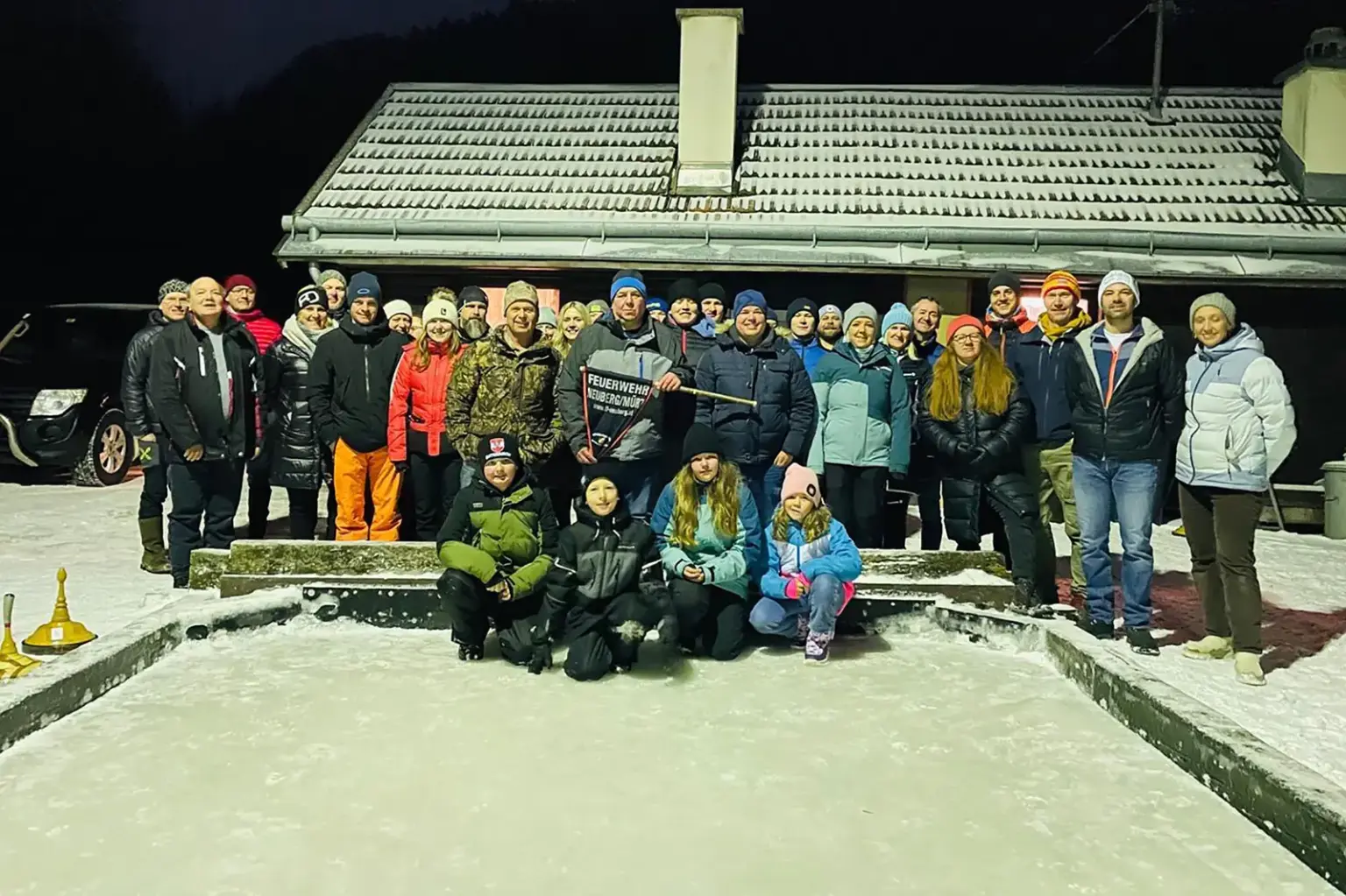 Rund 40 Personen in Winterkleidung auf einer Eisbahn