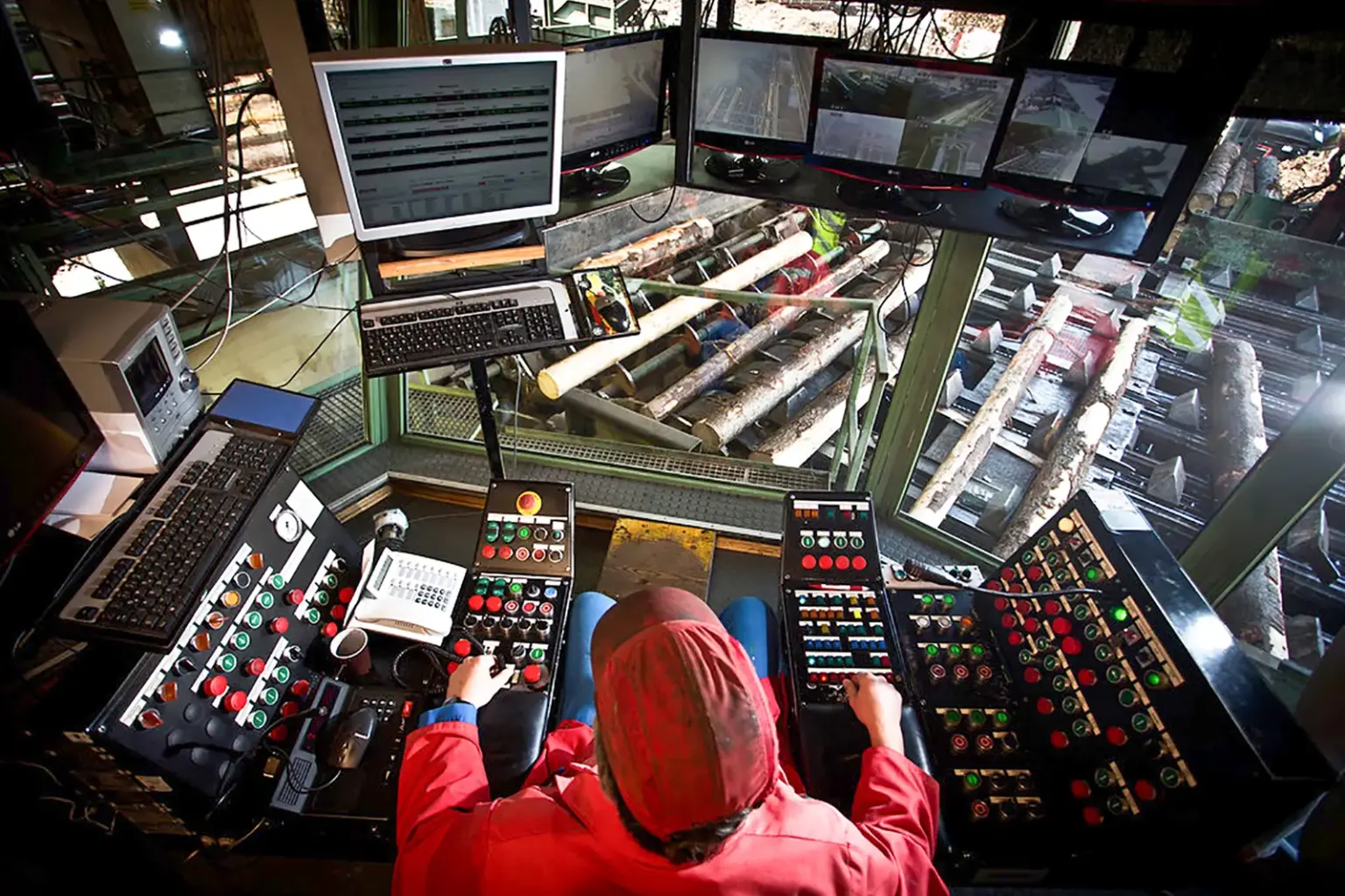 Ein Mann sitzt an einem Pult mit vielen Schaltern und Knöpfen