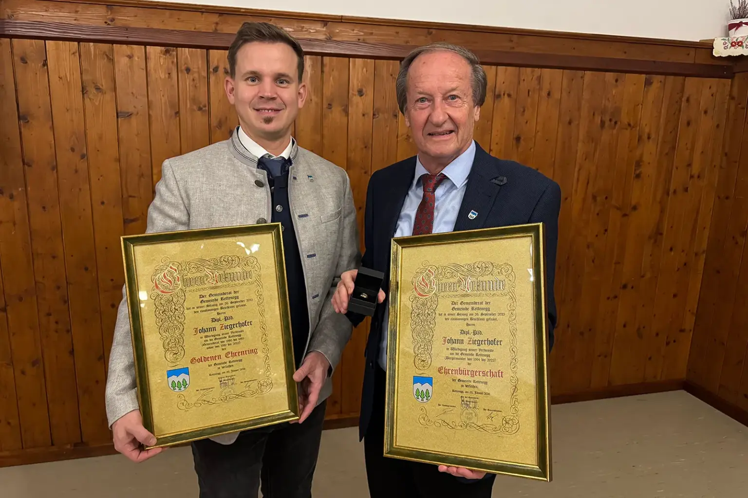 Zwei Männer halten zwei Urkunden