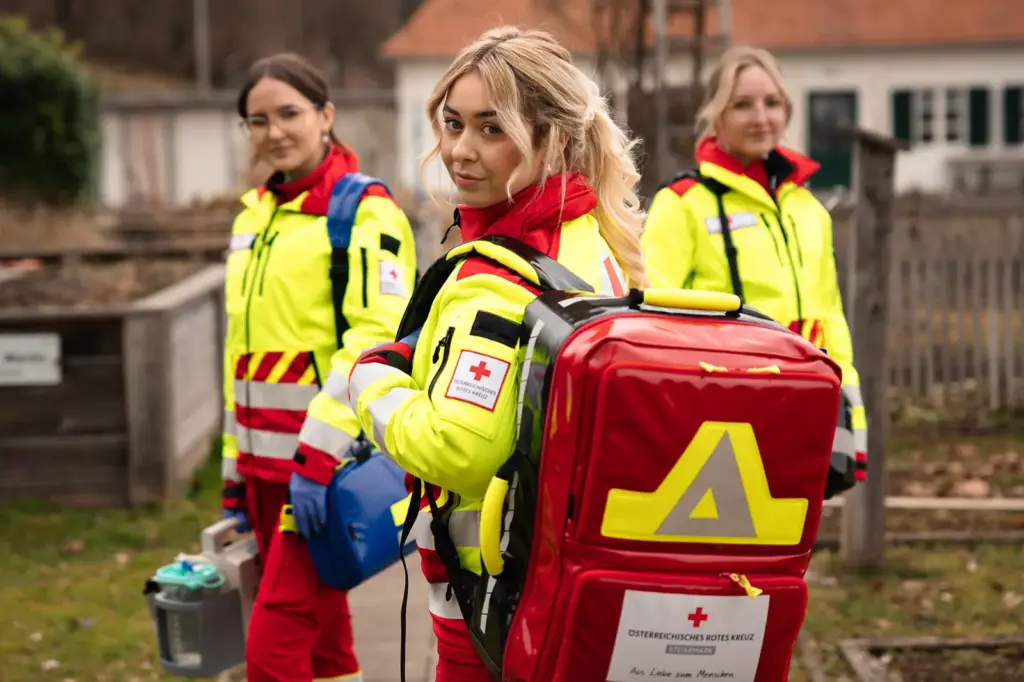 Drei junge Frauen in Rotkreuz-Dienstkleidung