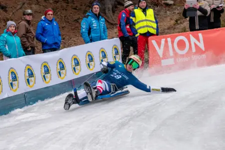 Ein Rodler auf einer vereisten Eisbahn.