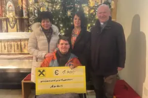 Spende von der Singrunde Vier Personen mti einem Spendenscheck in einer Kirche