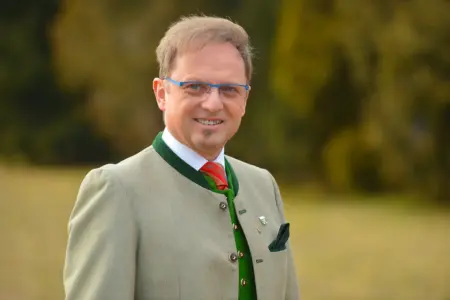 Ein Mann mit Brille, Trachtenjacke und roter Krawatte