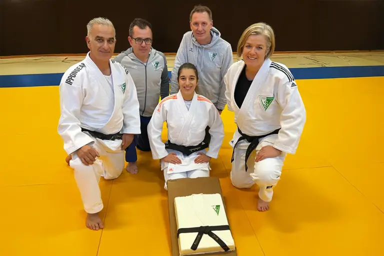 Fünf Menschen, drei davon tragen einen Judoanzug.