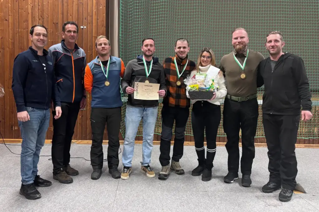 Acht Personen mit Preisen und einer Urkunde