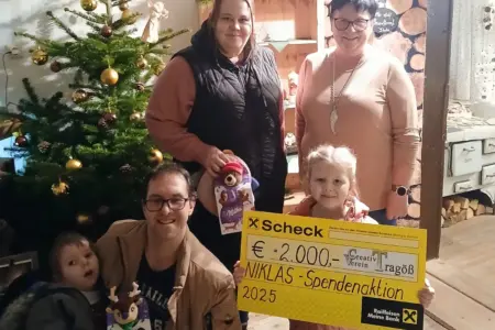 Zwei Kinder und drei Erwachsene vor einem Christbaum