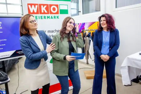 Viel Info und Geselligkeit Drei Damen stehen vor einem Banner mit dem Logo der Wirtschaftskammer Steiermark.