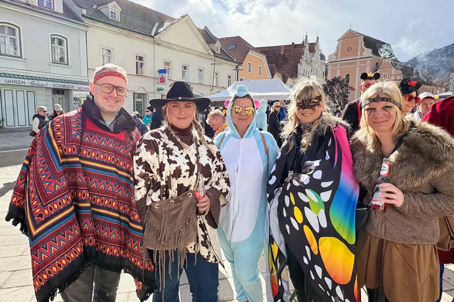 Fünf Personen in Kostümen bei einem Faschingsfest auf einem innerstädtischen Platz