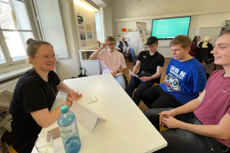 Mehrere Personen sitzen an einem Tisch